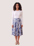 White long-sleeve layering shell on a model with a blue paisley skirt