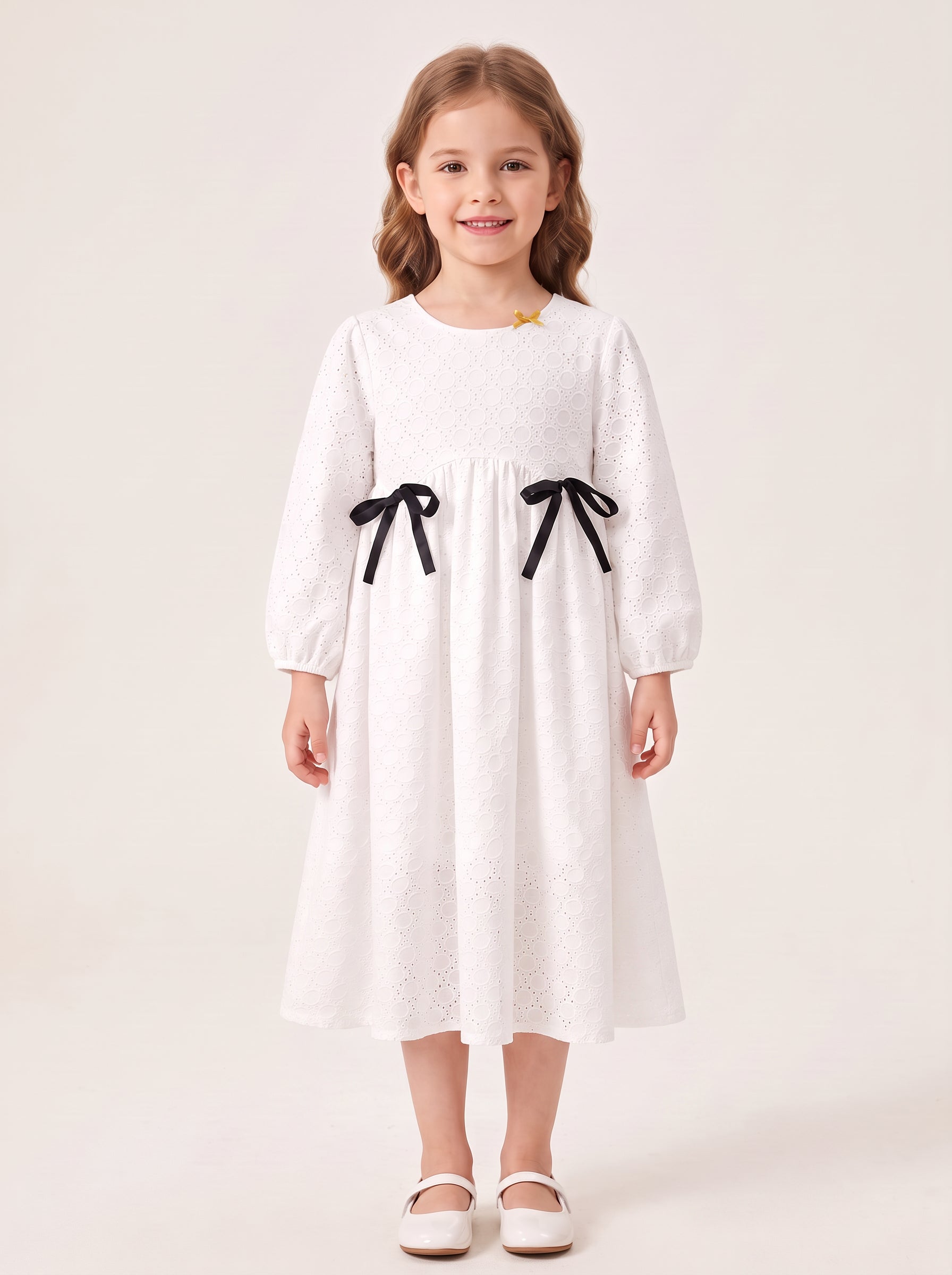 White eyelet bow dress on a girl, with skirt covering her knees