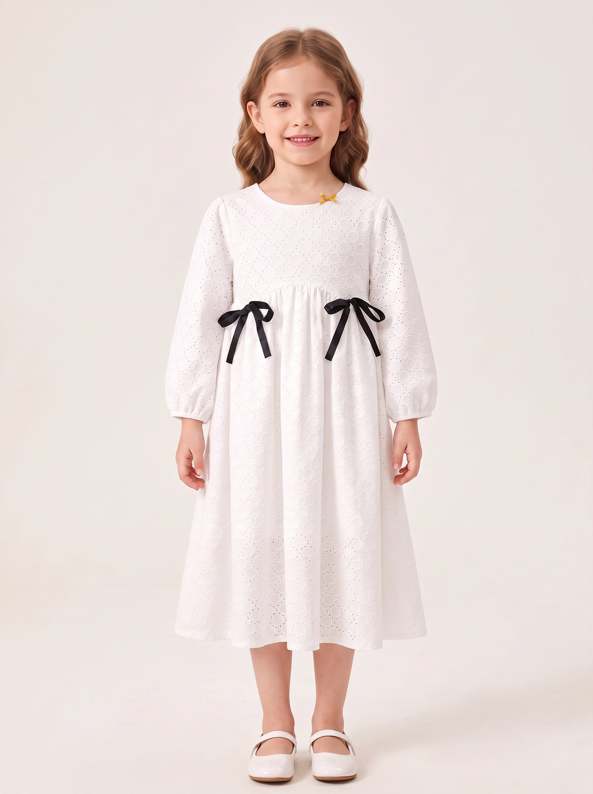 White eyelet bow dress on a girl, with skirt covering her knees