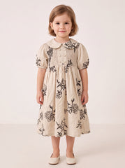 Beige floral smocked dress on a girl, knee-covering skirt