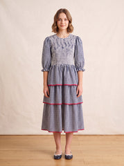 Navy gingham tiered dress on a girl, knee-covering skirt