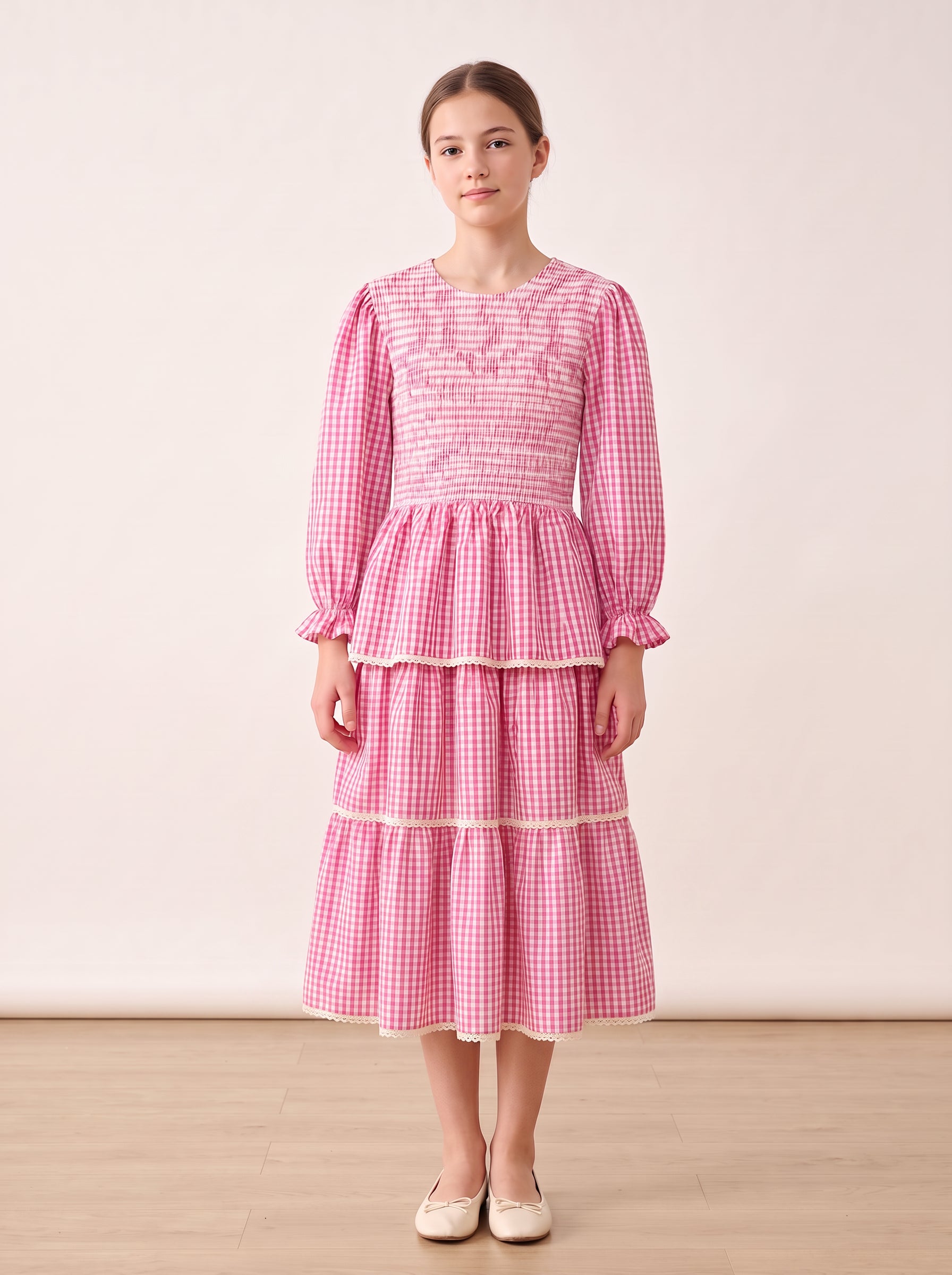 Pink gingham tiered dress on a girl, knee-covering skirt