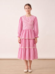Pink gingham tiered dress on a girl, knee-covering skirt