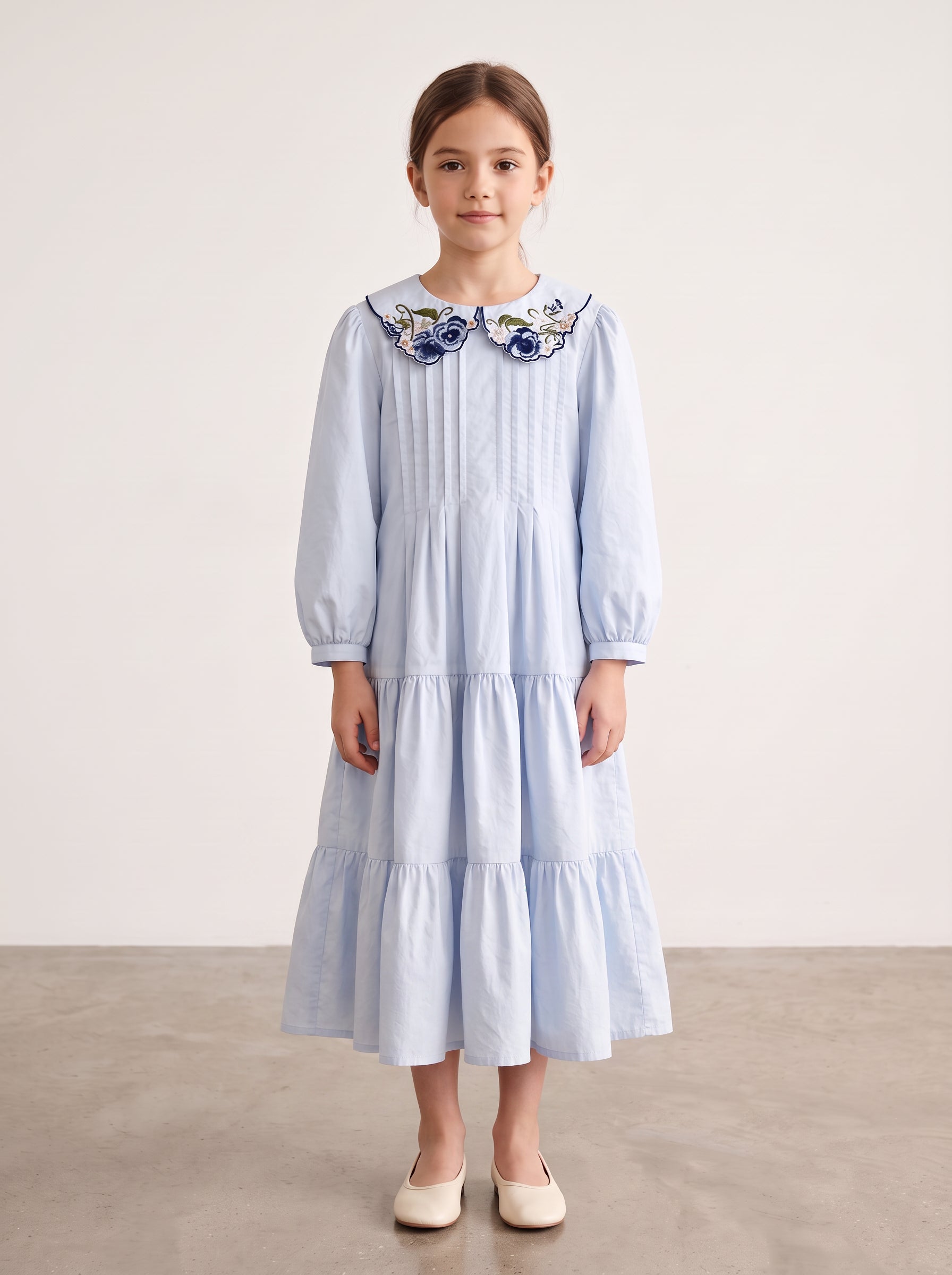 Light blue floral-collar pintuck dress on a girl, knee-covering skirt