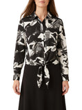Black and white abstract-print tie-front blouse with pointed collar and long sleeves on a model
