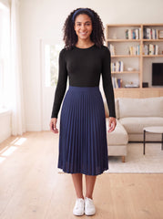 Black fitted long-sleeve layering shell, Style 6657-23, tucked into navy pleated skirt