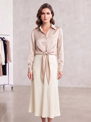 Neutral beige satin blouse styled with a visible front tie