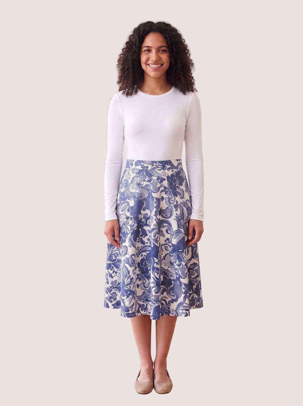 White long-sleeve layering shell on a model with a blue paisley skirt